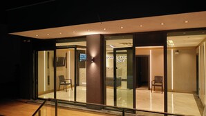 A modern hotel lobby with glass doors, a reception desk, and seating areas. - Doğal Termal Suit (Gediz)