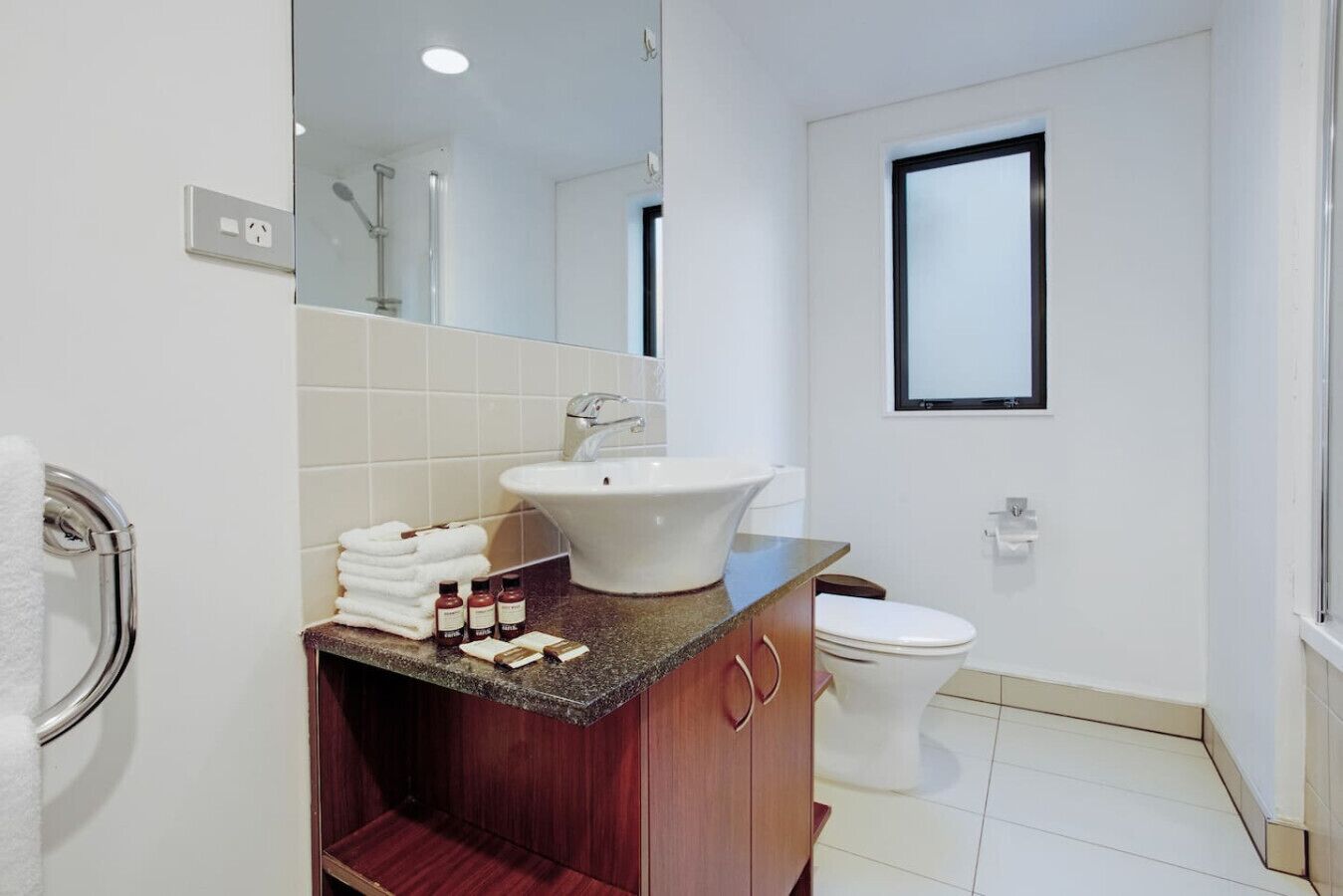Ein modernes Badezimmer mit Waschtisch, Spüle und Toilette.