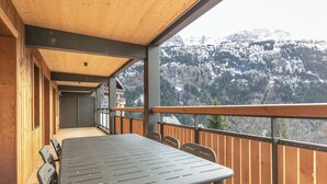 A wooden deck with a table and chairs, overlooking a snowy mountain landscape. - Les Hauts de Vaujany - Vacancéole (Vaujany)