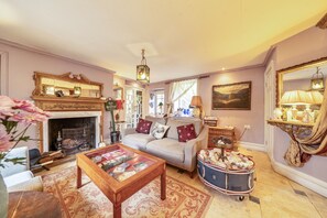 A cozy living room with a fireplace, a sofa, a coffee table, and a decorative cart. - Groves Hall Garden Apartment Sleights Near Whitby (Whitby)