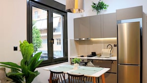 Eine kompakte Küche mit integriertem Kühlschrank, einem Esstisch mit Stühlen und einem großen Fenster mit Ausblick.