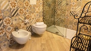 A bathroom with a bidet, toilet, and shower. - Mimosa Room Sea View (Torre Elisabetta) (Massa Lubrense)
