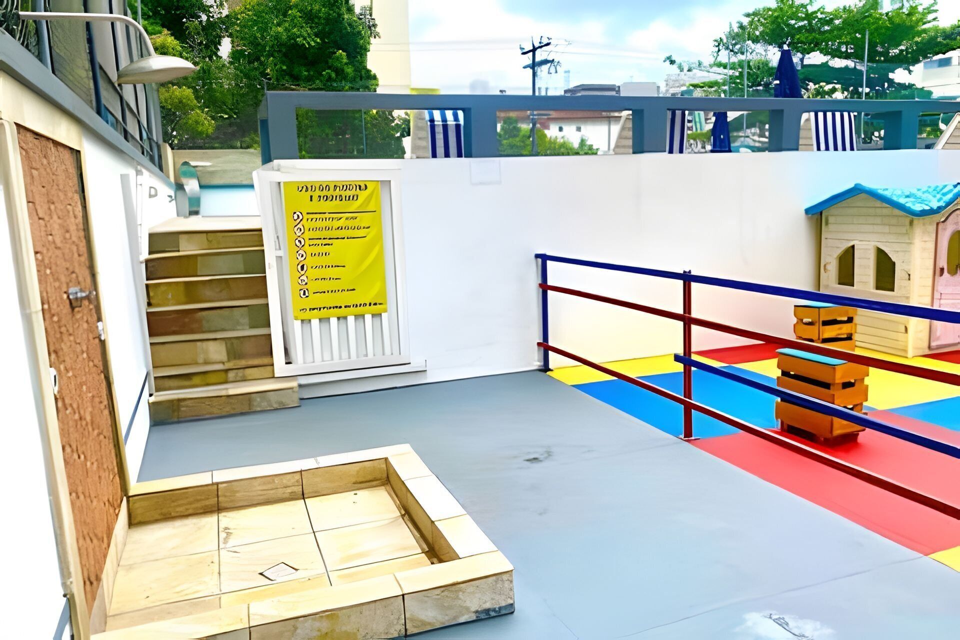 A children's play area with a small slide, a climbing wall, and a colorful floor.