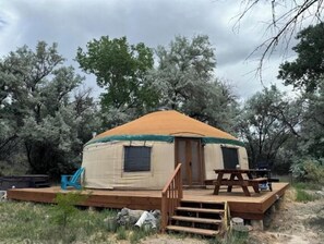Cozy yurha with a wooden deck and entrance.