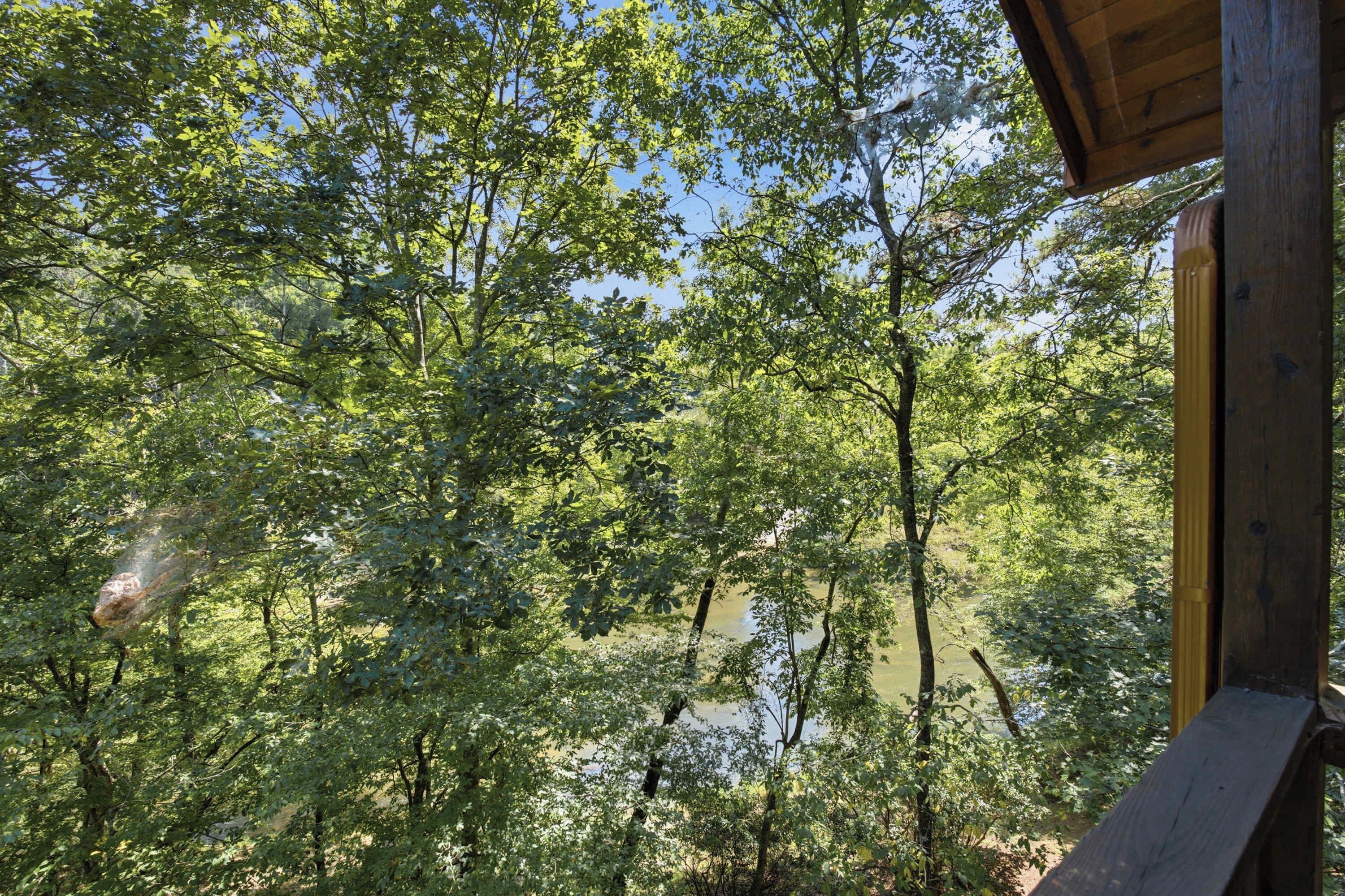 A wooden structure with a view of a forested area and a body of water.
