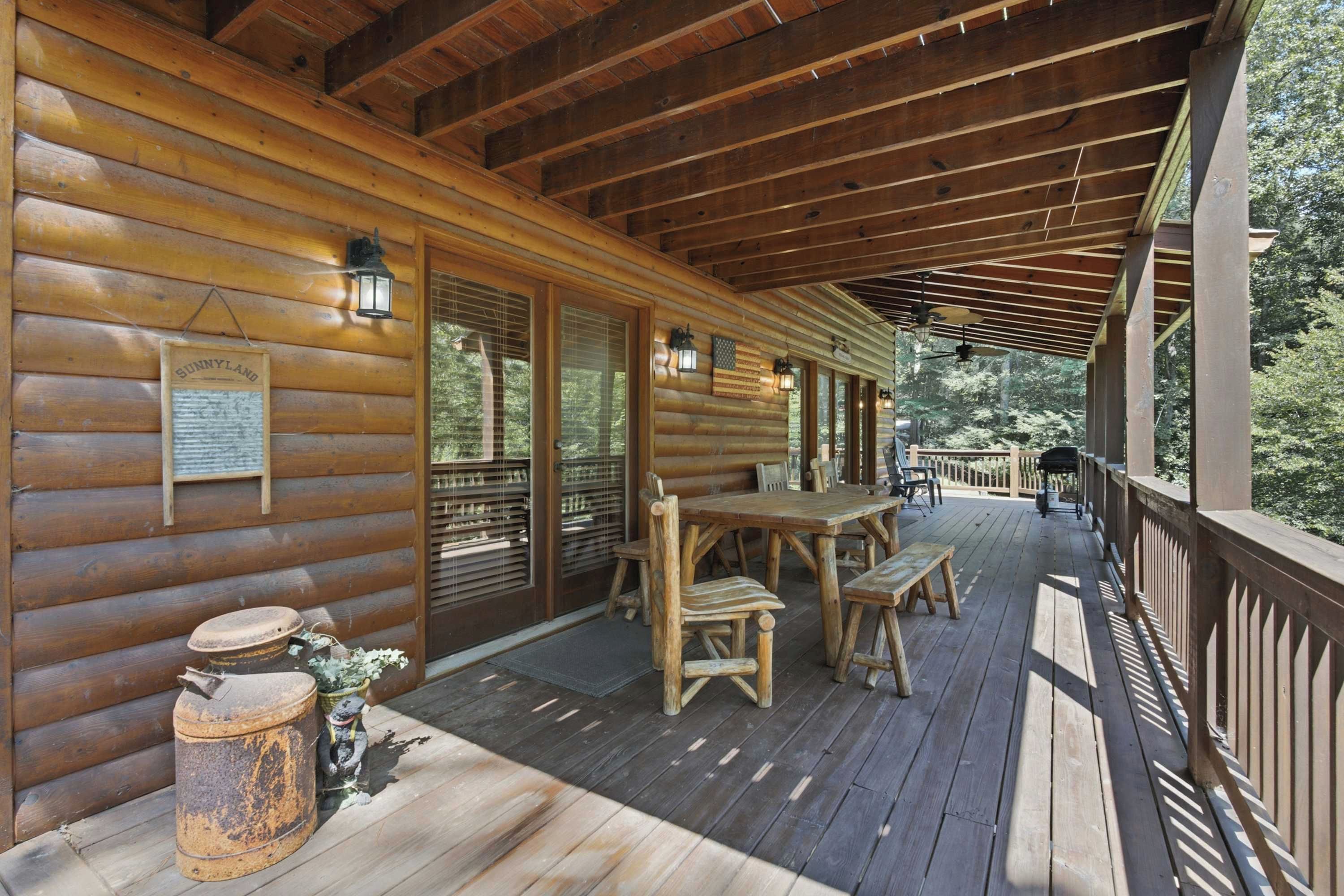 A wooden cabin with a covered porch, a table with chairs, and a rustic lantern.
