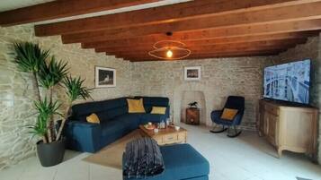 Departamento Deluxe, vista al jardín | Área de sala de estar | Televisión