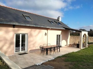 A house with a patio, a dining table with chairs, and a covered outdoor area. - Manoir de l'Aisnerie (Saint-Herblain)