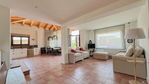 Amplia sala de estar con cocina, mesa de comedor y asientos.