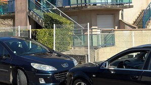 Une maison à deux étages avec un balcon, un escalier et une voiture garée devant.