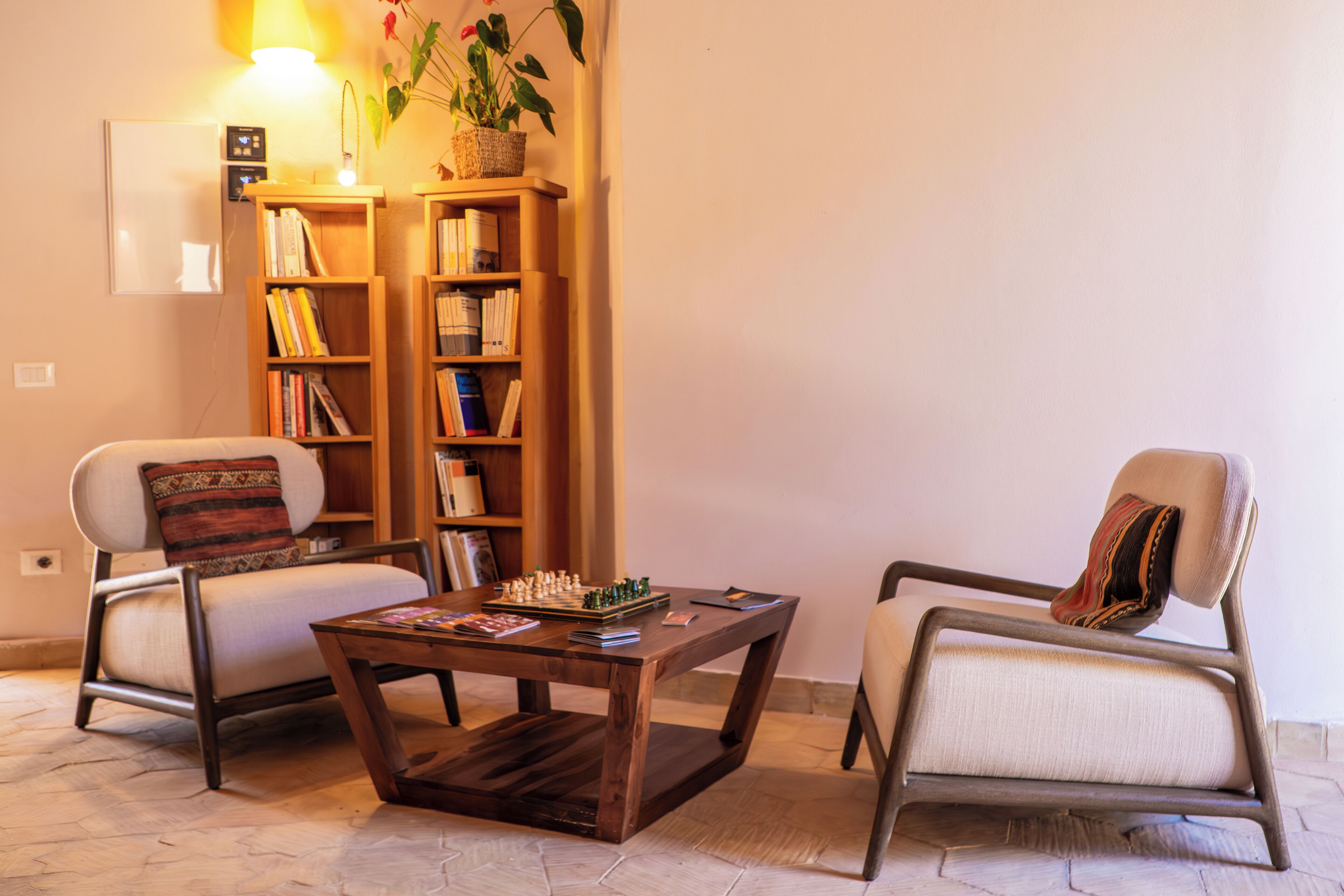 Una sala de estar con dos sillones, una mesa de centro y una estantería.
