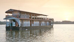 A large houseboat with multiple decks, equipped with fans and life rings, floating on calm water. - Houseboats By DAE Colombo (Piliyandala)