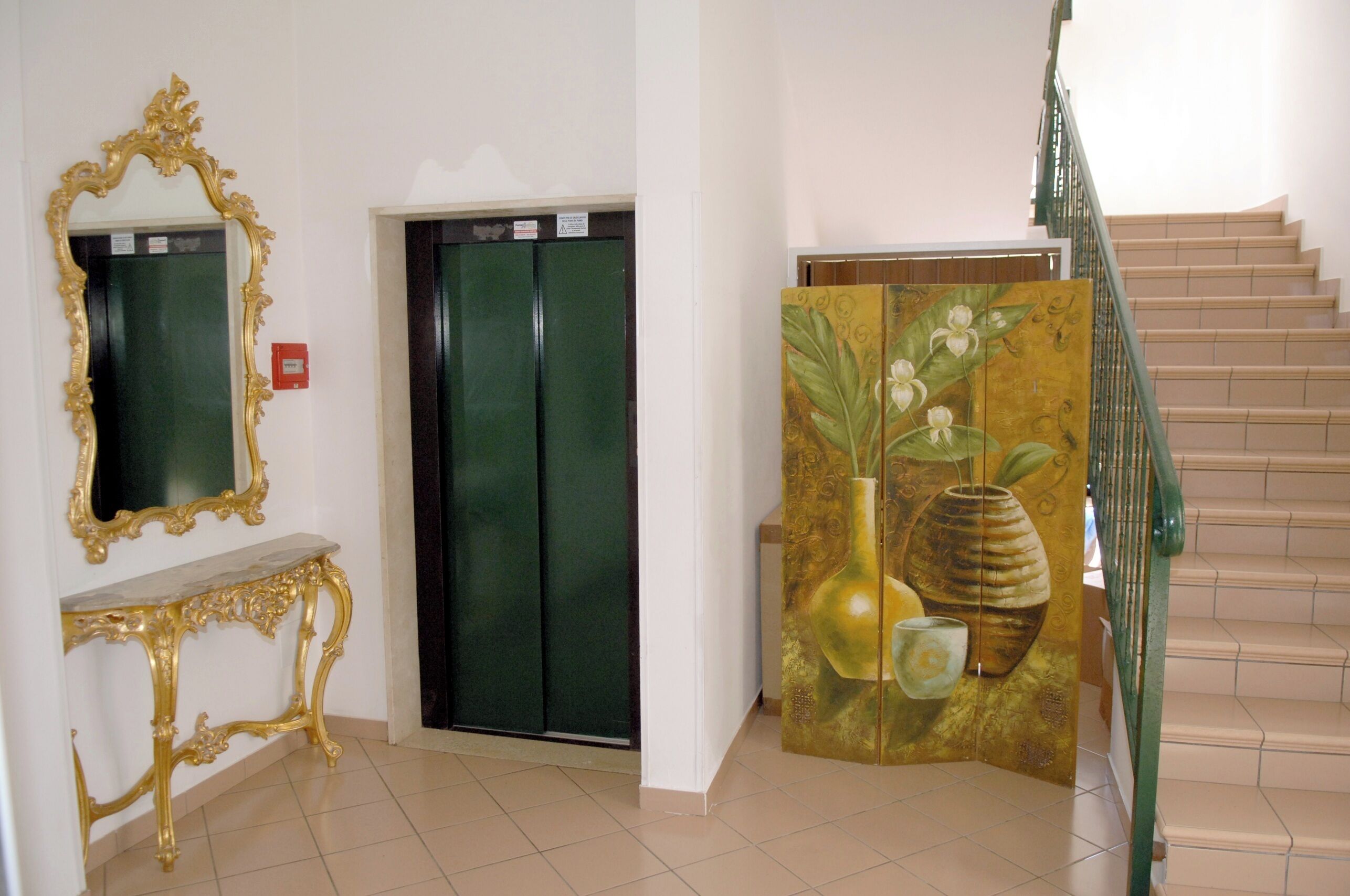 An elevator, a staircase, and a decorative panel with a floral design.