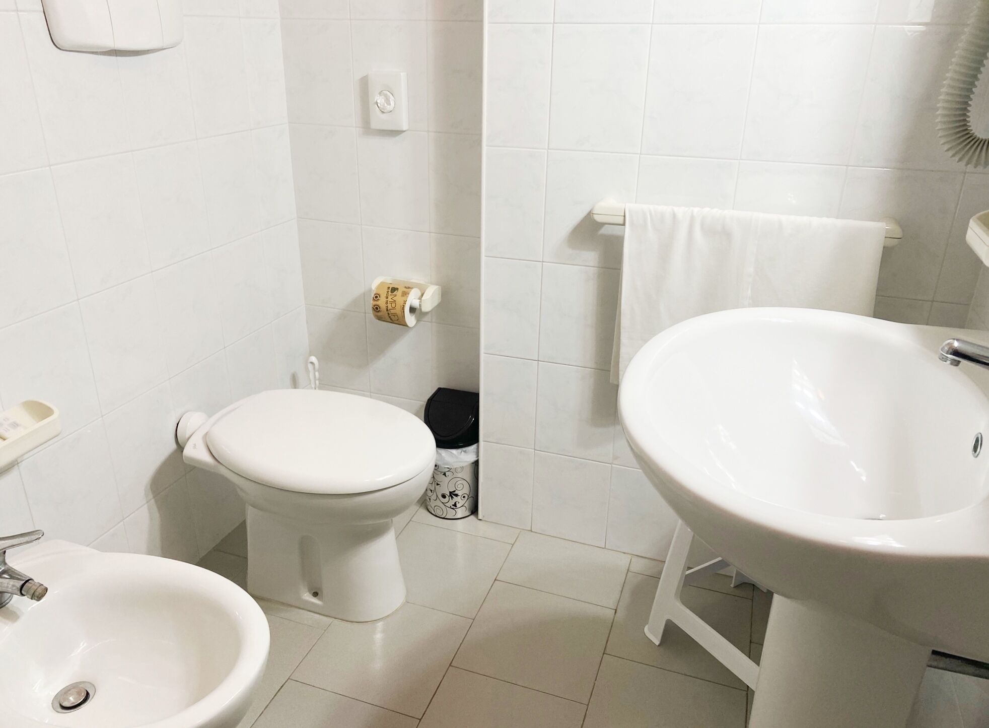 A bathroom with a toilet, bidet, and sink.