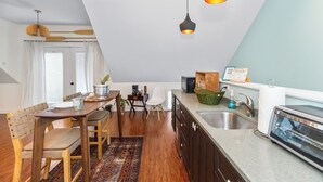 Een moderne keuken met een eethoek, houten meubels en hanglampen.