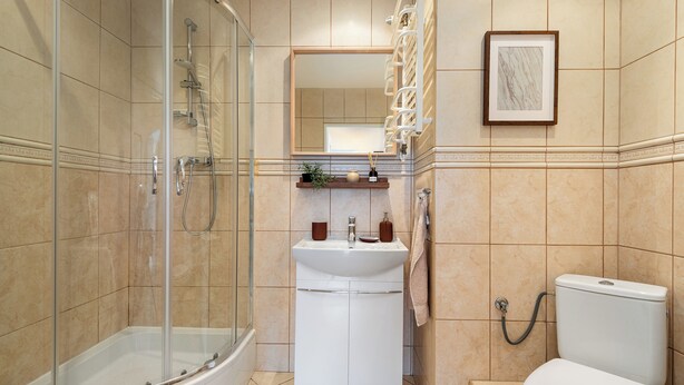 Une salle de bain avec une douche à parois de verre, un lavabo blanc et des toilettes.