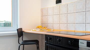 Une cuisine avec une chaise noire, un plan de travail orné de citrons et une cuisinière.