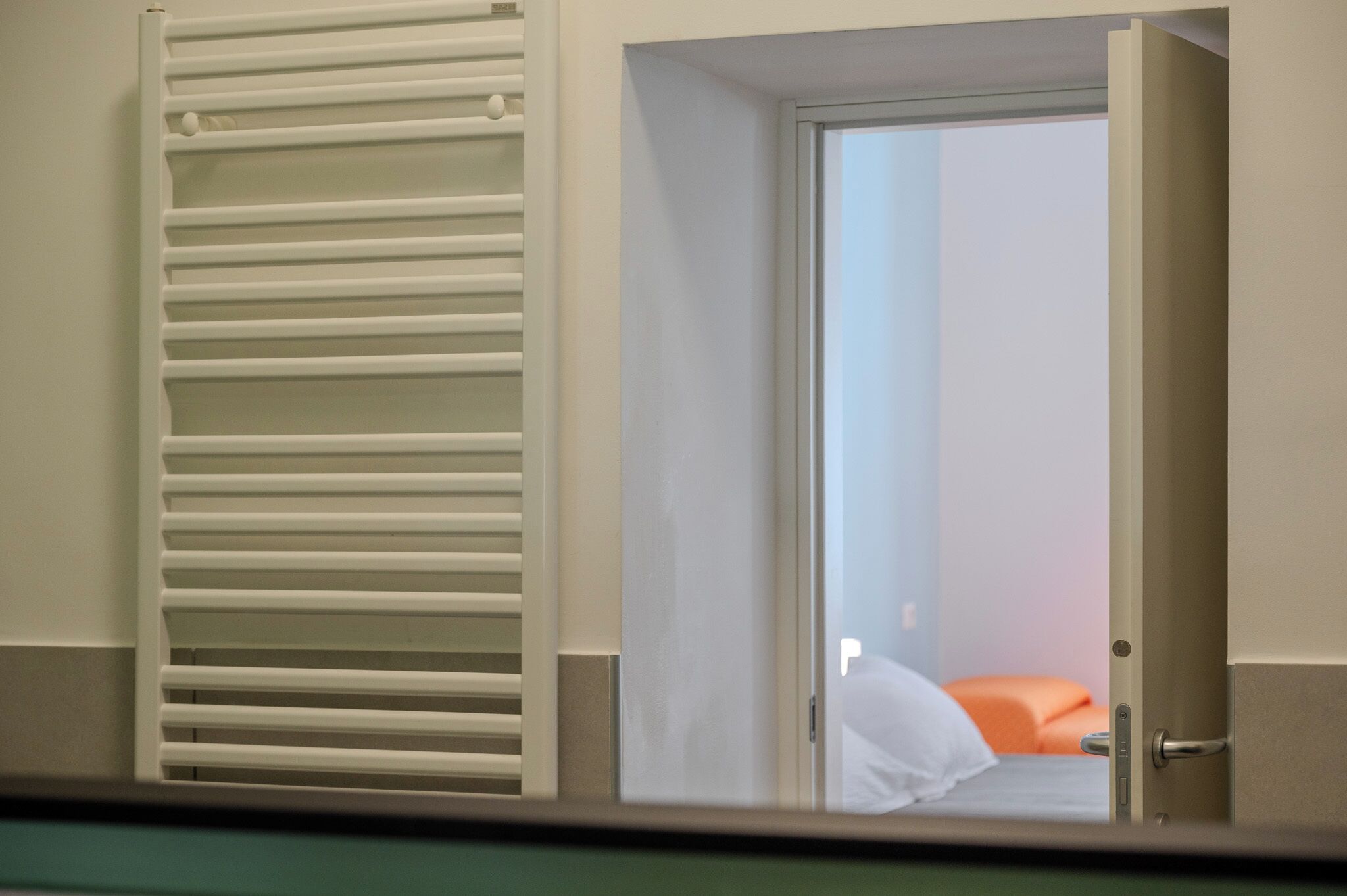 A room with a bed, a door, and a radiator.