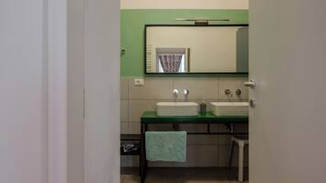 Une salle de bain avec deux lavabos, un miroir et une serviette accrochée au mur.