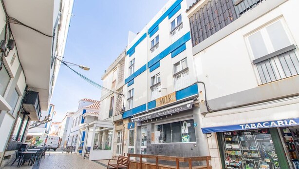 A narrow street with buildings on either side, including a coffee shop and a store named 'Tabacaria'. - Nesha Surf Flat Ericeira (Mafra)