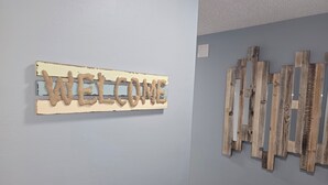 A wall with a 'WELCOME' sign and wooden wall decor.