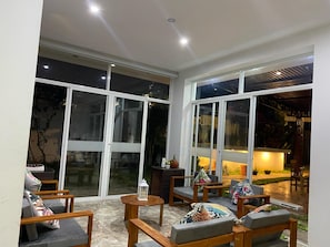 A spacious patio area with a seating arrangement, large glass doors, and a view of the outdoors.