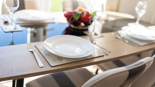 A dining table set with plates, cutlery, and a glass of water. - Derry House - spacious 3 bed house with driveway (Aberdeen)