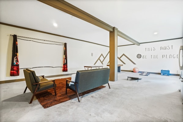 Un interior moderno con sofá, sillón y una pared con texto motivacional.