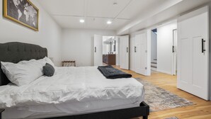 Quarto moderno com cama grande, mapa-múndi na parede e vista para o banheiro.