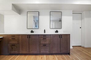 A modern bathroom with a large vanity, two mirrors, and a white countertop.