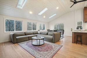 A spacious living room with a sectional sofa, a round coffee table, and a patterned rug.