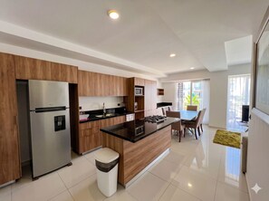 A modern kitchen with a central island, stainless steel appliances, and wooden cabinetry.