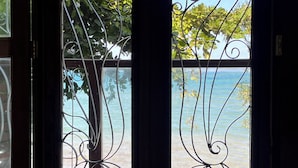 Ein Schlafzimmer mit Blick auf das Meer durch ein Metallgitter.