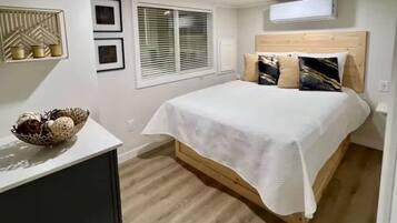 A bedroom with a bed, bedside table, and a decorative wall piece.