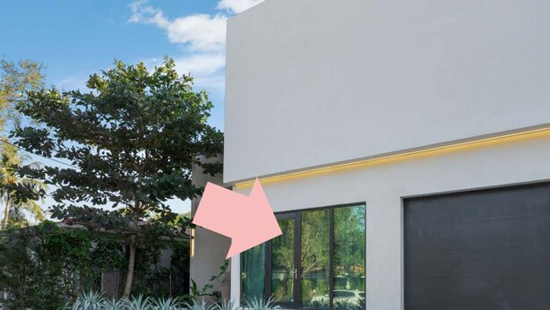 Ein modernes Haus mit einer großen Garage, einem gepflegten Rasen und verschiedenen Pflanzen.