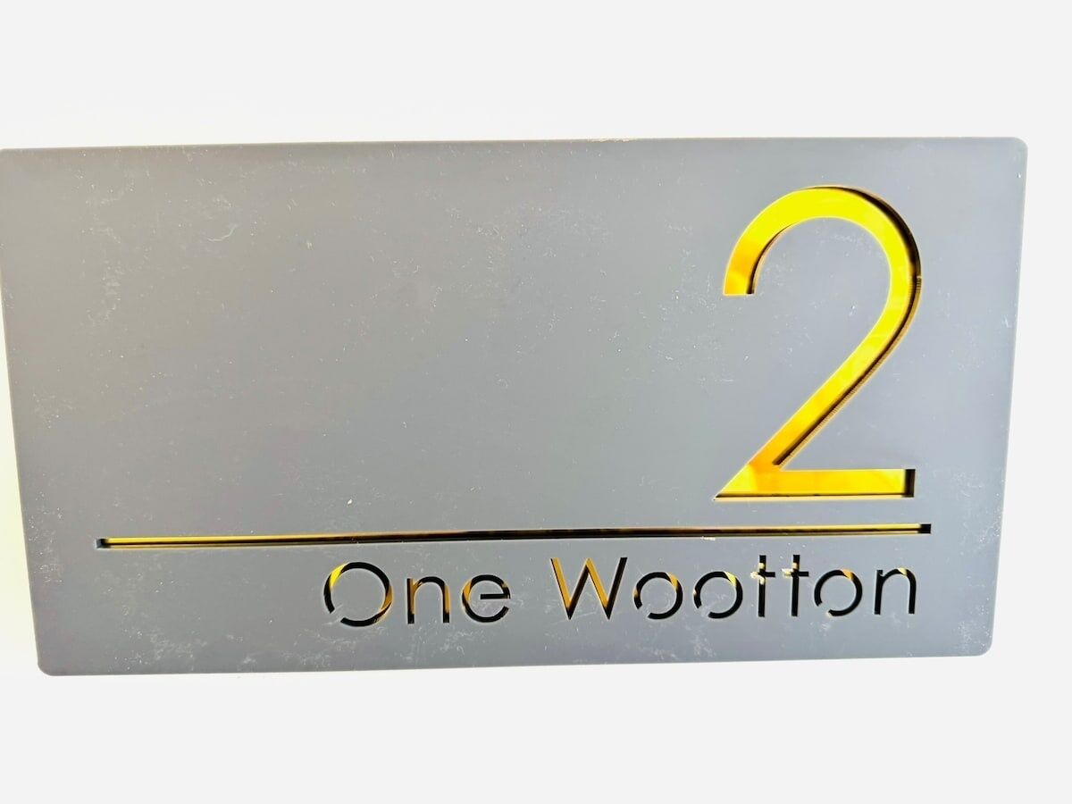 Ein Schild mit der Nummer 2 und dem Text 'One Wootton'.