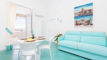 Apartamento, vista para o mar | Área de estar | TV de tela plana 32 polegadas com canais digitais