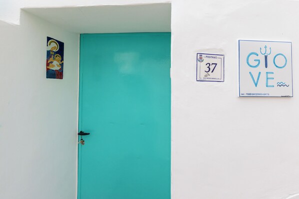 A turquoise door with a small sign above it and a framed picture on the wall. - YourHome - Giove Positano (Positano)