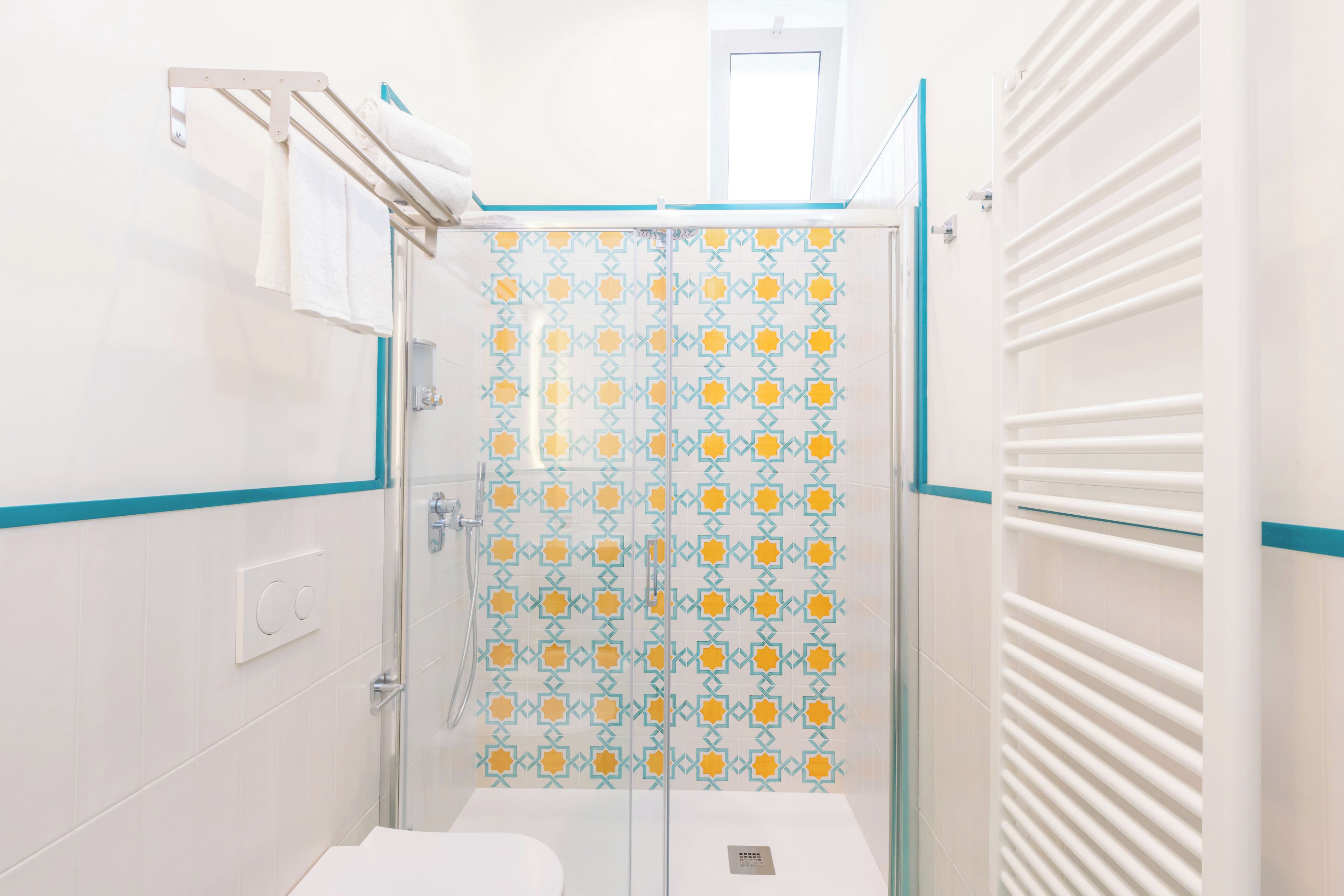 A small bathroom with a shower, a toilet, and a towel rack.