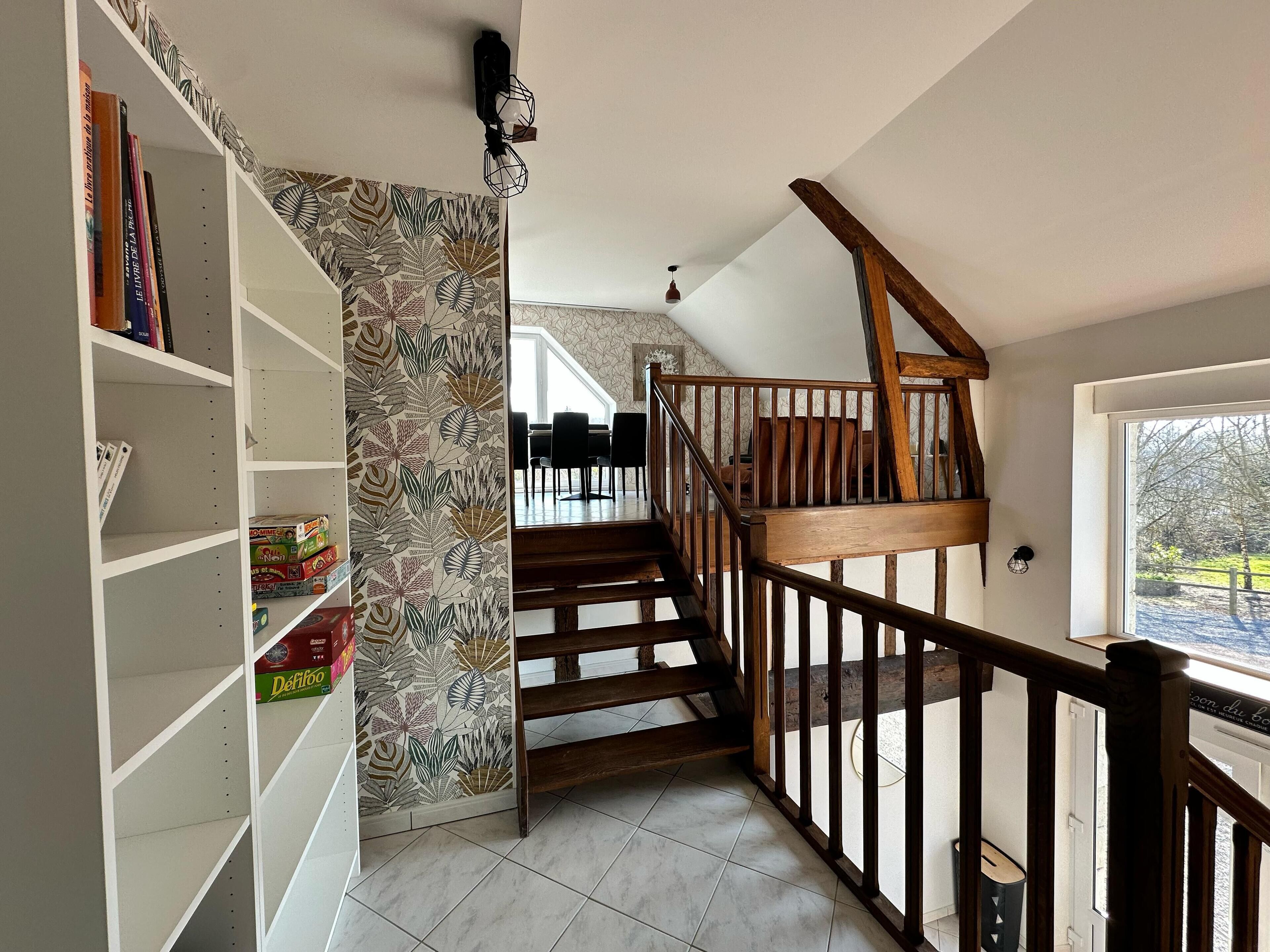 A staircase with wooden railings leading to a dining area.