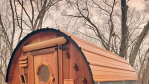 A wooden barrel-shaped structure with a door and a sign that reads "NOMAD". - Serenity Shack (Wellsboro)