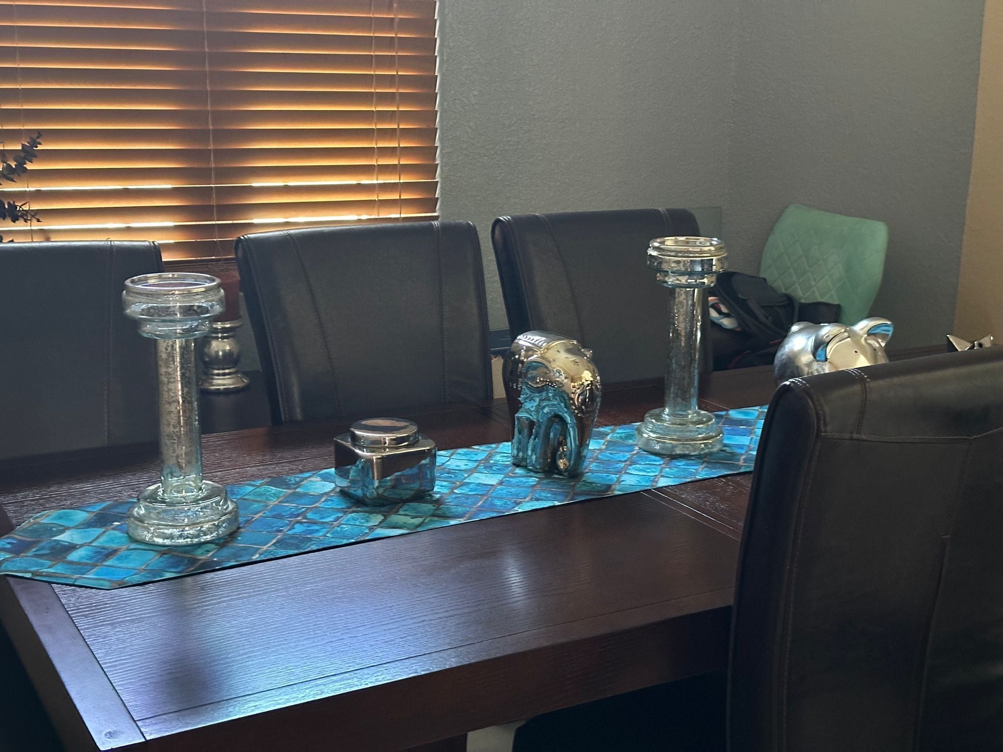 Una mesa de comedor con un mantel estampado en azul, rodeada de sillas.