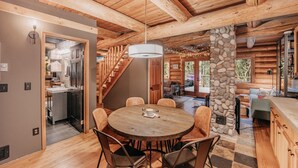 A wooden interior with a round dining table, chairs, a stone pillar, and a staircase leading to a second floor. - 81sl - Hot Tub - Wifi - Pets Ok - Sleeps 4 (Deming)