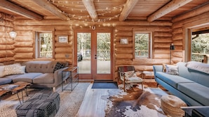 A log cabin interior with two sofas, a coffee table, and a rug. - 81sl - Hot Tub - Wifi - Pets Ok - Sleeps 4 (Deming)