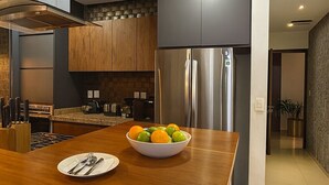 Eine moderne Küche mit Edelstahlgeräten, einer Holz Arbeitsplatte und einer Obstschale.
