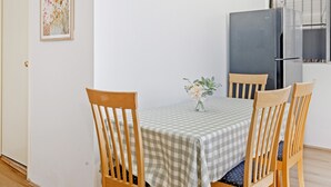 Un comedor con mantel a cuadros, sillas de madera y un pequeño florero.