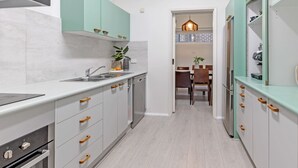 A modern kitchen with light-colored cabinets, a stainless steel sink, and a built-in oven. - Kozyguru | Forestville | Charming 3Br House (Forestville)