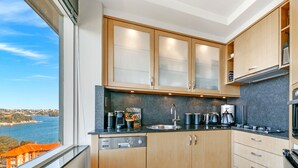 Eine moderne Küche mit Holzausstattung, einem eingebauten Backofen und Meerblick.