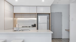 Una cocina moderna con armarios blancos, una isla central y un horno empotrado.