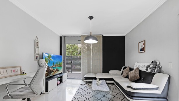 A modern living room with a sofa, a TV, and a desk.